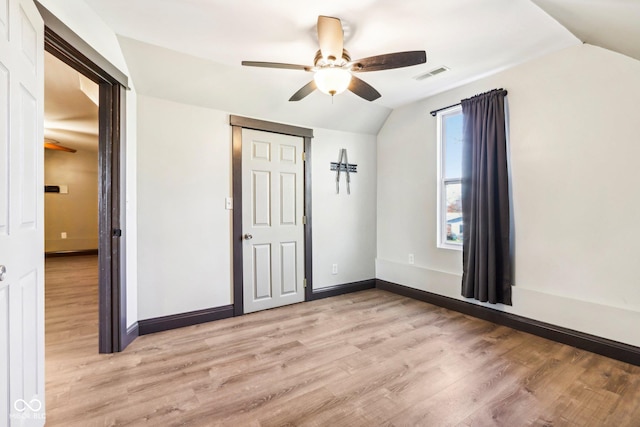 unfurnished bedroom with light wood-type flooring, a closet, ceiling fan, and lofted ceiling