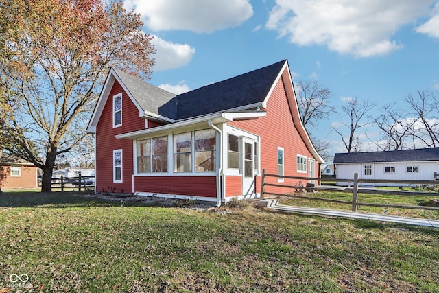 view of front of house featuring a sunroom and a front yard