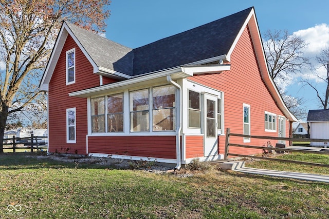 view of side of home with a lawn and a sunroom