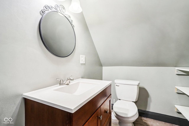 bathroom with vanity, lofted ceiling, and toilet