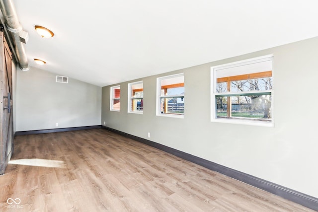 spare room with lofted ceiling and hardwood / wood-style flooring