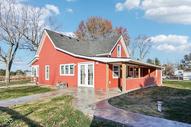 view of side of property with a yard and french doors