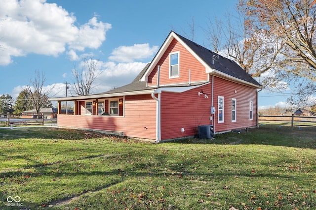 view of side of home featuring cooling unit and a lawn