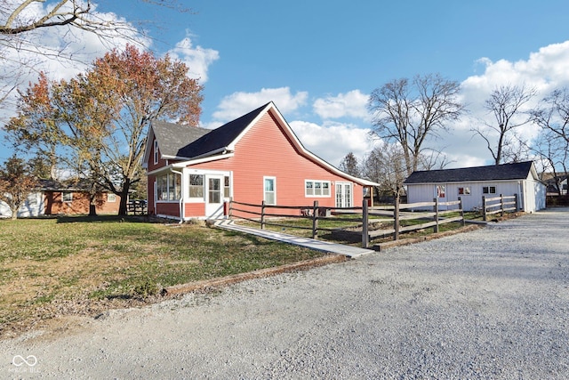 view of side of property featuring an outbuilding, a yard, and a garage