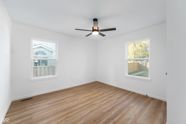 spare room with ceiling fan, a healthy amount of sunlight, and light hardwood / wood-style floors