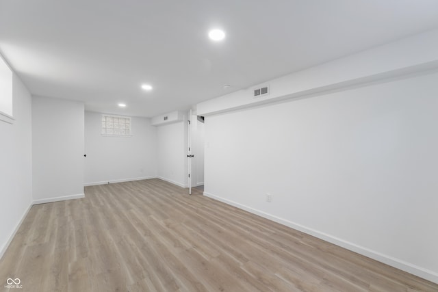 basement with light hardwood / wood-style flooring