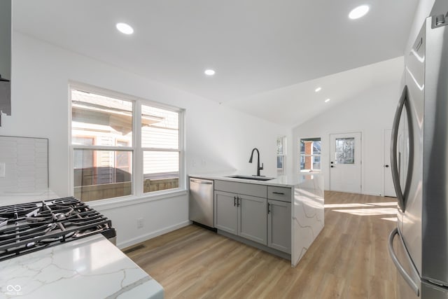 kitchen with stainless steel appliances, light hardwood / wood-style flooring, a healthy amount of sunlight, and sink