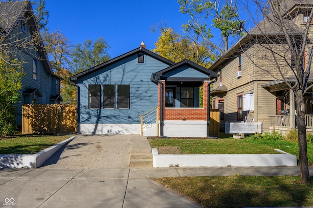 bungalow-style home with a porch and a front lawn