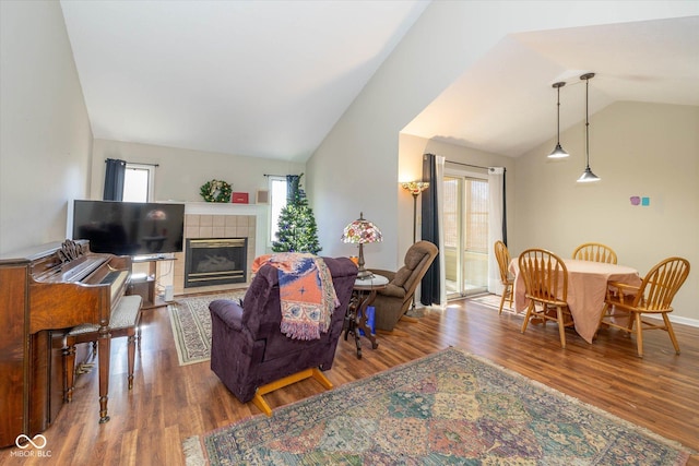 living room with lofted ceiling, a fireplace, and hardwood / wood-style floors