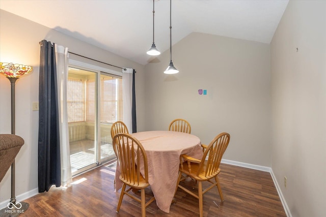 dining space with vaulted ceiling and dark hardwood / wood-style flooring