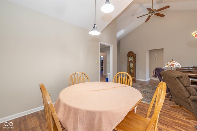 dining area with ceiling fan, dark hardwood / wood-style floors, and high vaulted ceiling