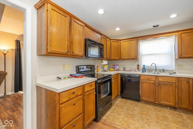 kitchen with light hardwood / wood-style floors, sink, and black appliances