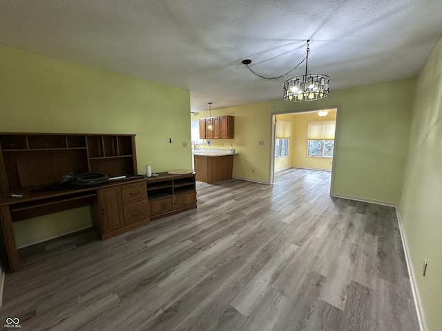 kitchen featuring hardwood / wood-style floors, decorative light fixtures, a textured ceiling, and a notable chandelier