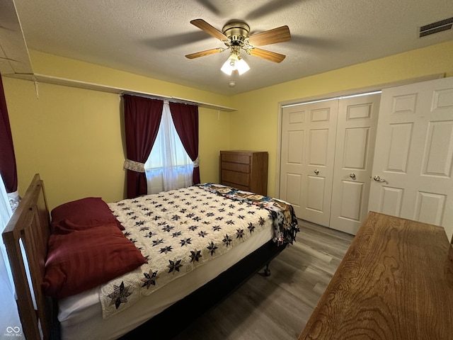 bedroom with ceiling fan, a closet, a textured ceiling, and light wood-type flooring