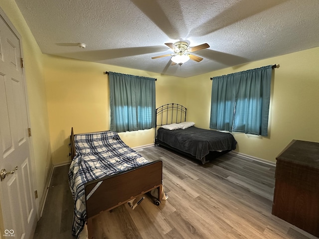 bedroom featuring hardwood / wood-style floors, a textured ceiling, and ceiling fan