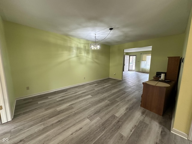 unfurnished dining area featuring hardwood / wood-style floors and a chandelier