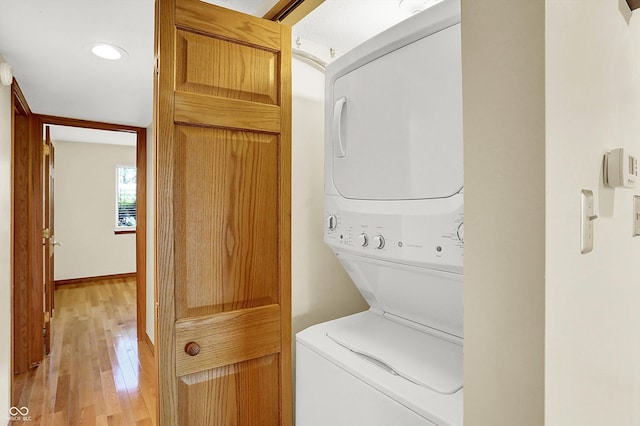 washroom featuring stacked washing maching and dryer and light wood-type flooring