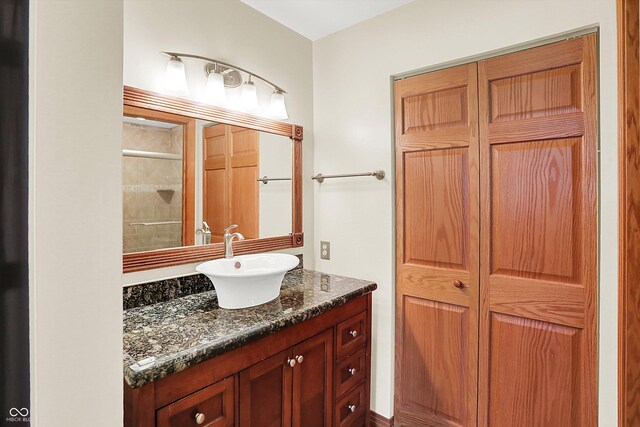 bathroom featuring a shower with door and vanity