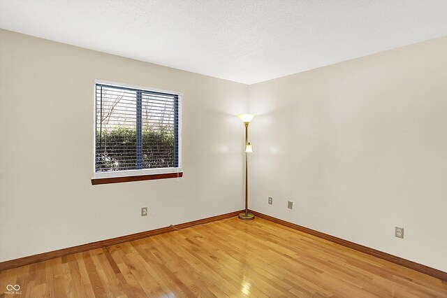 unfurnished room featuring hardwood / wood-style floors and a textured ceiling