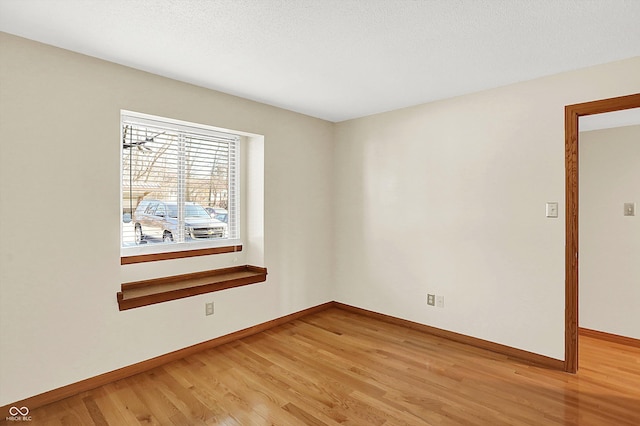 unfurnished room with hardwood / wood-style floors and a textured ceiling