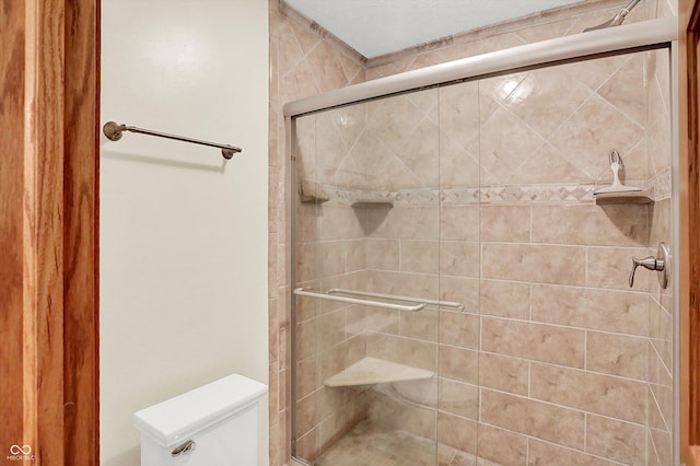 bathroom featuring toilet and an enclosed shower