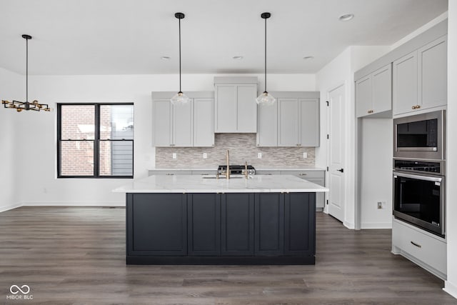 kitchen featuring tasteful backsplash, light stone counters, dark hardwood / wood-style flooring, and stainless steel appliances