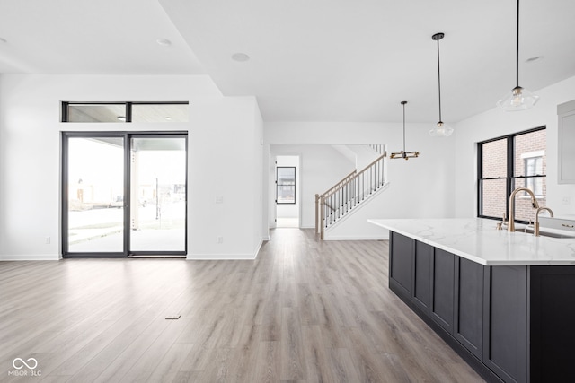 unfurnished living room with sink and light hardwood / wood-style flooring