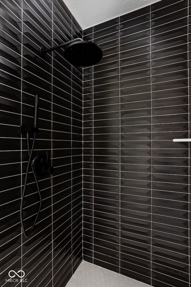 room details featuring a tile shower and a textured ceiling