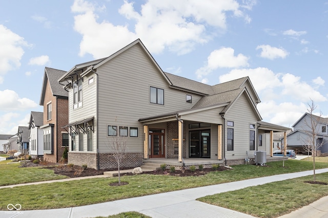 view of front of home featuring a front yard, a porch, and central AC unit