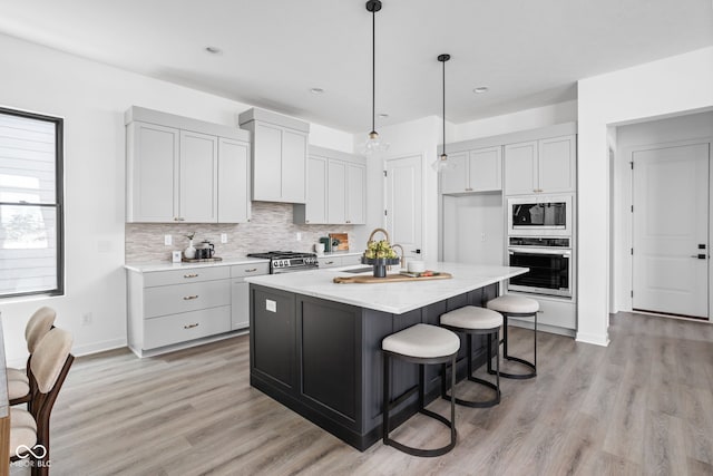 17366 Newton Main St, Westfield, IN 46074 - kitchen featuring appliances with stainless steel finishes, backsplash, light wood finished floors, pendant lighting, and recessed lighting