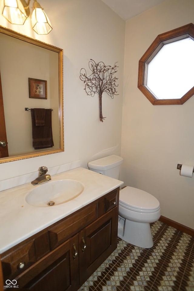 bathroom with tile patterned flooring, vanity, and toilet