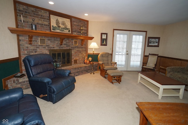 carpeted living room with french doors and a brick fireplace