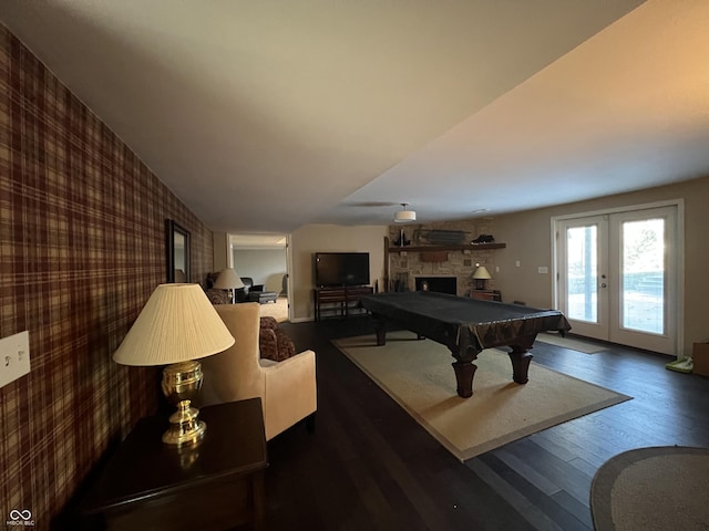 playroom with french doors, a stone fireplace, dark wood-type flooring, and billiards