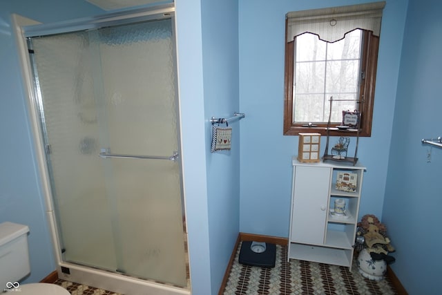 bathroom with tile patterned flooring, toilet, and walk in shower