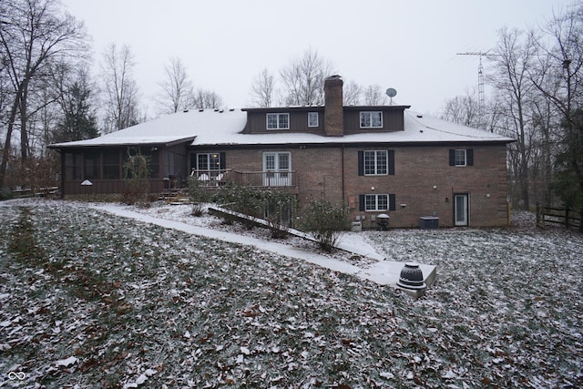 snow covered property featuring a sunroom