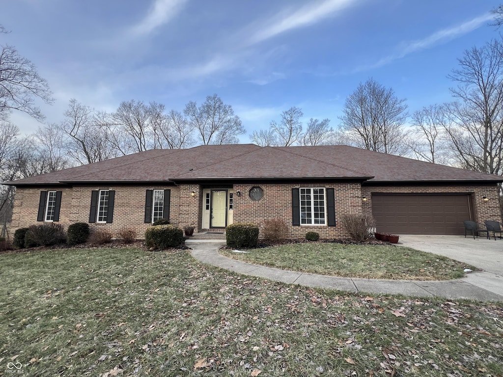 single story home featuring a garage and a front lawn