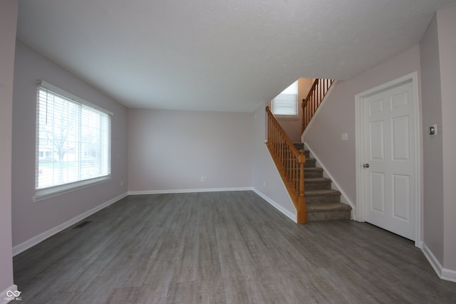 interior space featuring a textured ceiling and dark hardwood / wood-style flooring