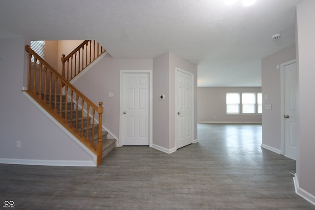 hall with wood-type flooring and a textured ceiling