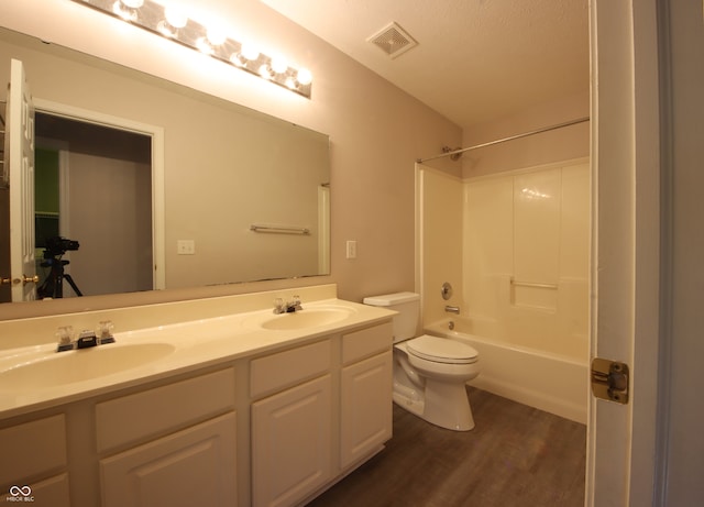 full bathroom with vanity, hardwood / wood-style flooring,  shower combination, and toilet