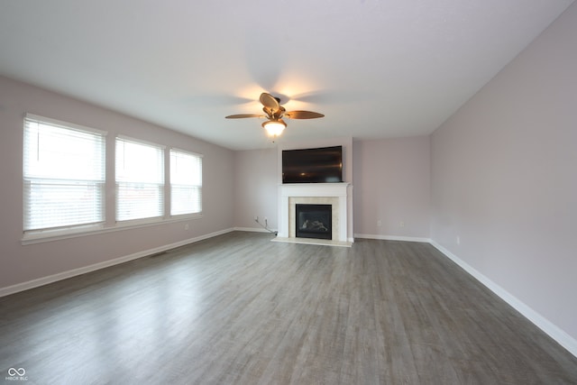 unfurnished living room featuring dark hardwood / wood-style flooring and ceiling fan