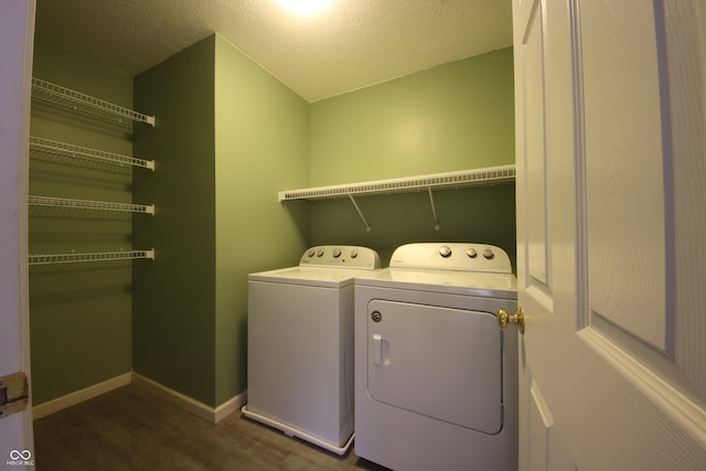 laundry room featuring dark hardwood / wood-style flooring, washer and dryer, and a textured ceiling