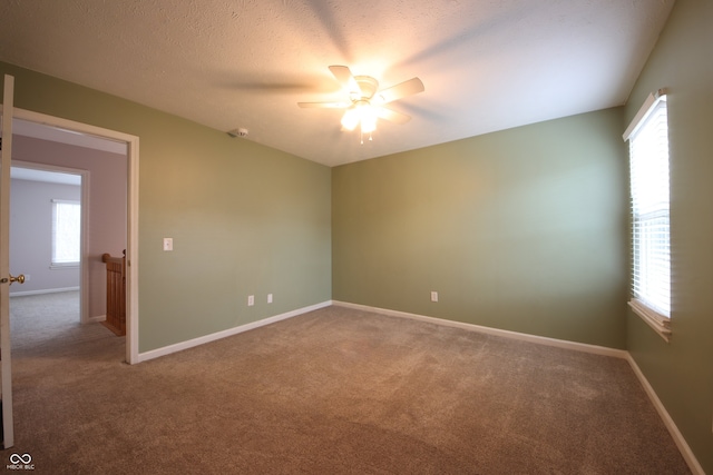 spare room featuring ceiling fan, carpet, and a textured ceiling