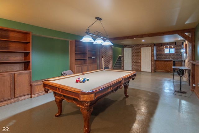 14446 Chapelwood Ln, Fishers, IN 46037 - playroom featuring brick wall, pool table, concrete flooring, and built in shelves