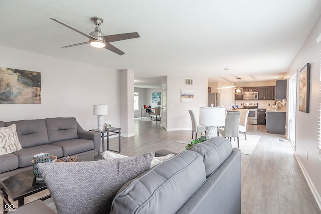 14446 Chapelwood Ln, Fishers, IN 46037 - living area featuring light wood-style floors, baseboards, ceiling fan, and visible vents
