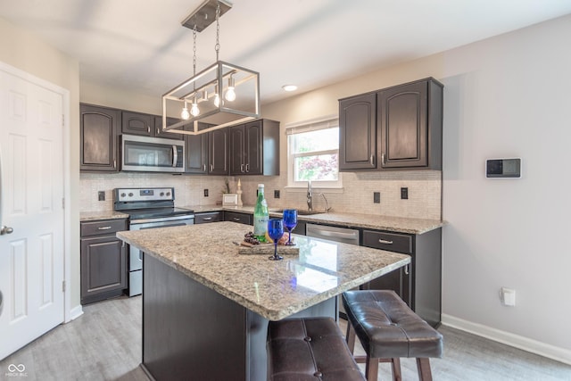 14446 Chapelwood Ln, Fishers, IN 46037 - kitchen featuring a sink, light stone counters, decorative backsplash, and stainless steel appliances
