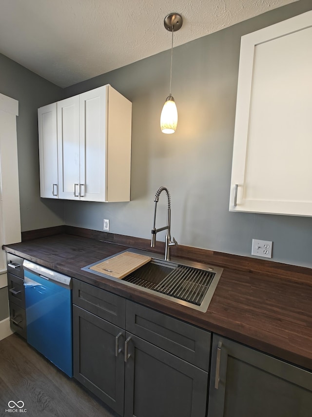 kitchen featuring white cabinets, dark wood-type flooring, sink, pendant lighting, and dishwasher