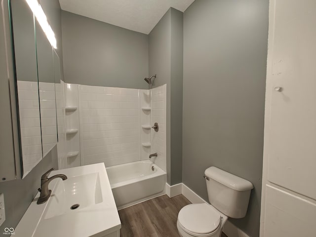 full bathroom featuring sink, washtub / shower combination, a textured ceiling, toilet, and hardwood / wood-style flooring