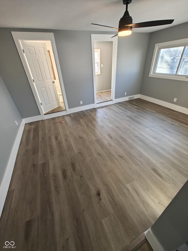 spare room with dark hardwood / wood-style floors and ceiling fan