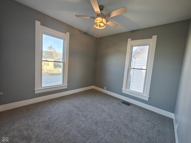 carpeted spare room with ceiling fan