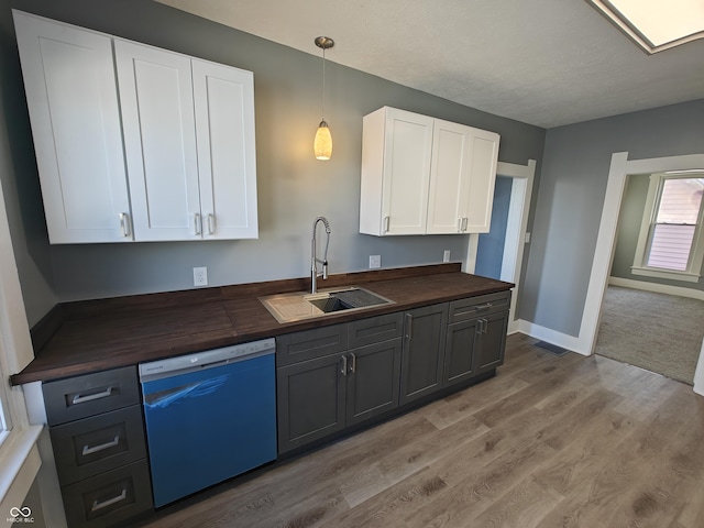 kitchen with dishwasher, white cabinets, light hardwood / wood-style floors, and sink